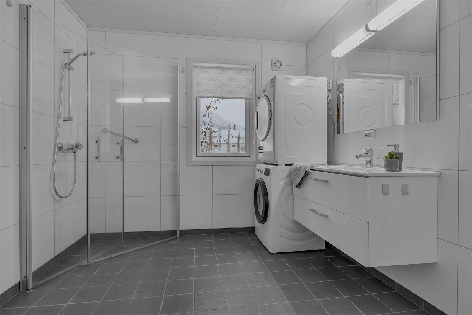 Rommet har innredning med nedfelt servant, toalett, dusjvegger/hjørne og opplegg for vaskemaskin. Elektrisk styrt vifte Galleribilde