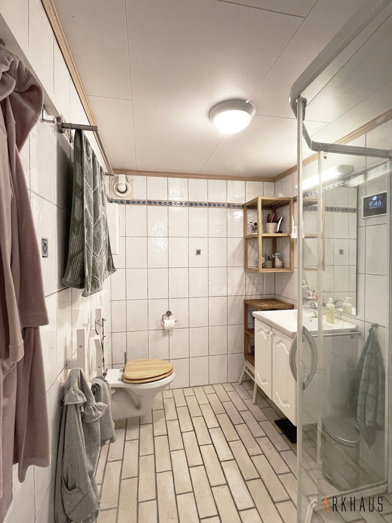 Fullt fungerende flislagt bad fra ca. 2005 med vegghengt toalett, vegghengte hyller og vegghengt servantskap Galleribilde