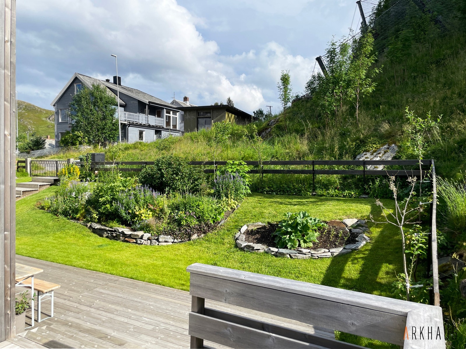 Fint blikk fra verandaen til plenen med staudebedet Galleribilde