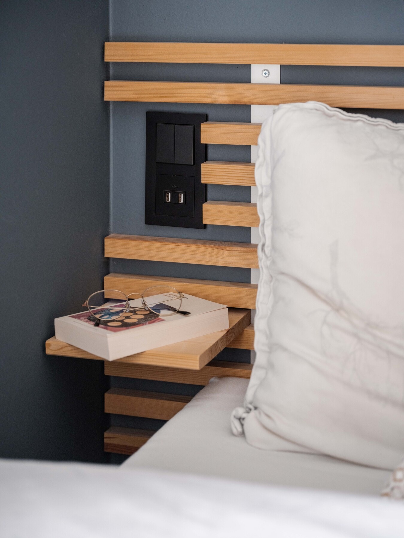 Plassbygget sengegavl med nattbord og stikkontakter på hver side av sengen. Galleribilde