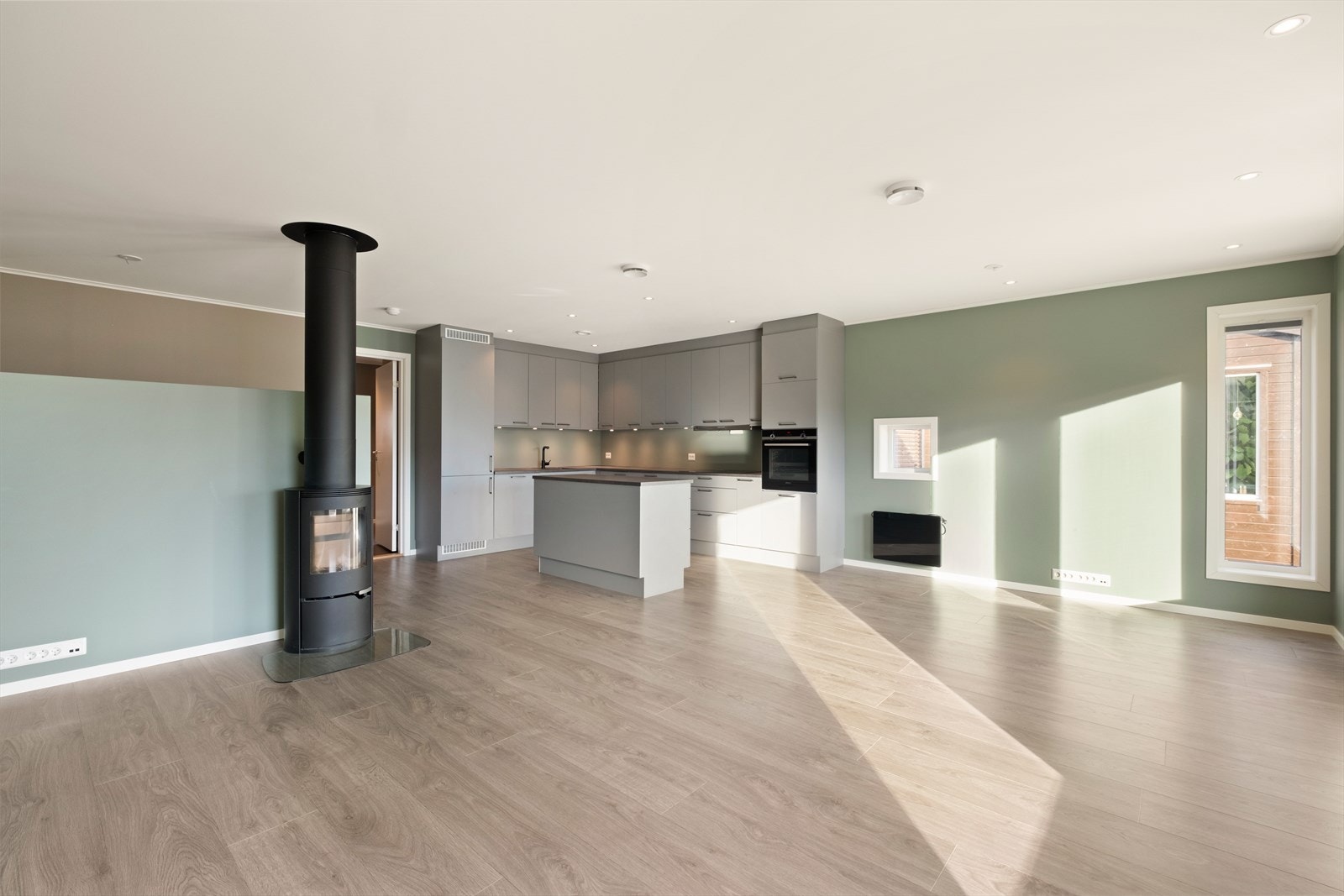 Åpen løsning mellom kjøkken og stue skaper et romslig oppholdsrom. Galleribilde