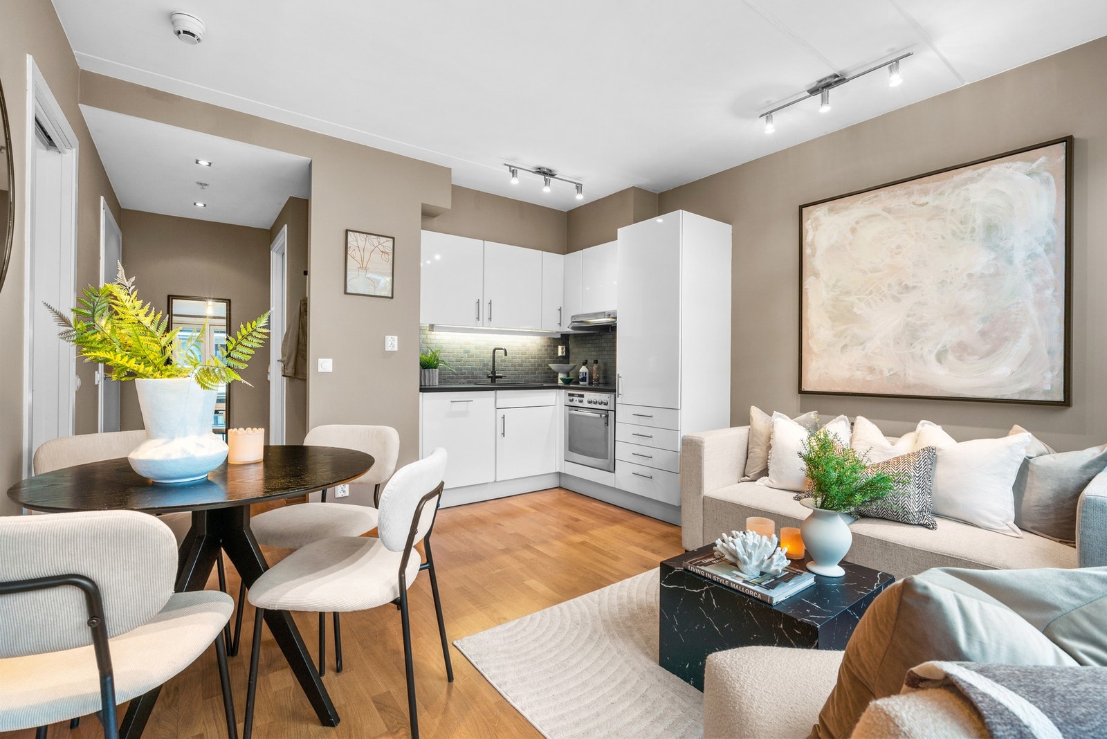 Kjøkkenet er oppført i hjørnet, med slette fronter, laminert benkeplate og oppvaskkum av kvartskomposit. Galleribilde