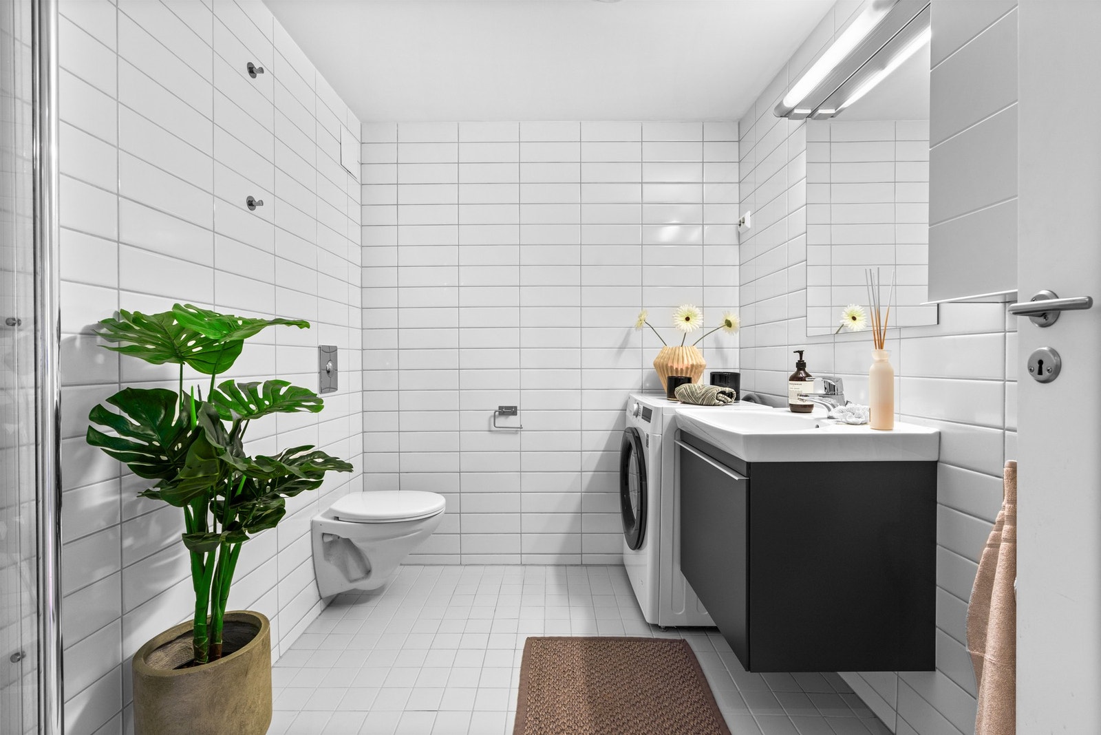 Dagene får en god start på et stort, stilrent bad med termostatstyrte varmekabler, vegghengt toalett og opplegg for vaskemaskin. Galleribilde