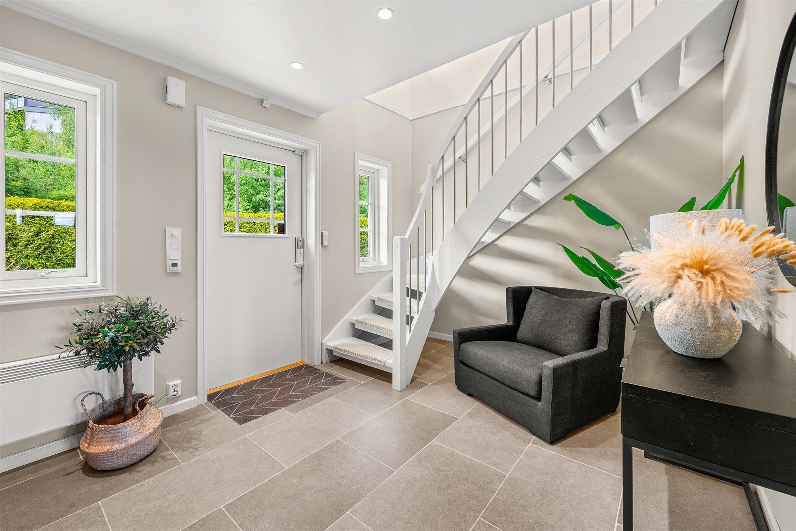 Velkommen hjem til en lys og trivelig entré som gir et varmt førsteinntrykk. Her møtes du av naturlig lys og en innbydende atmosfære, perfekt for å ønske gjester velkommen! Galleribilde