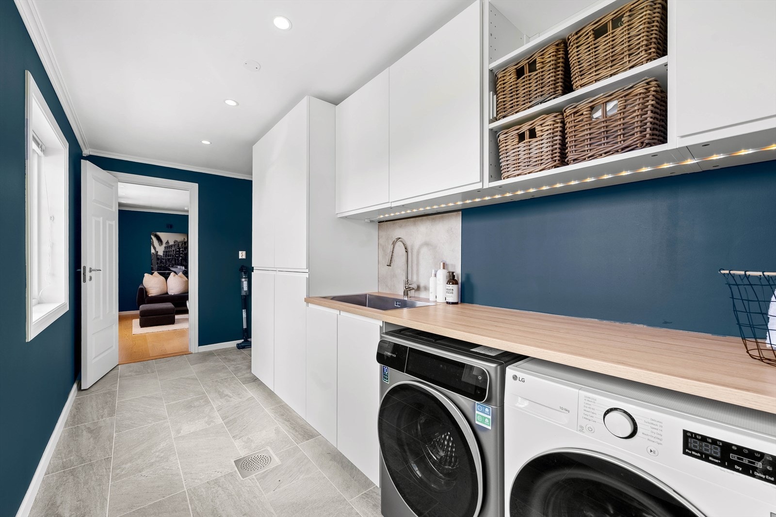 Praktisk og funksjonelt vaskerom med rikelig skapplass og benkeplass til oppbevaring. Perfekt for å holde orden. Galleribilde