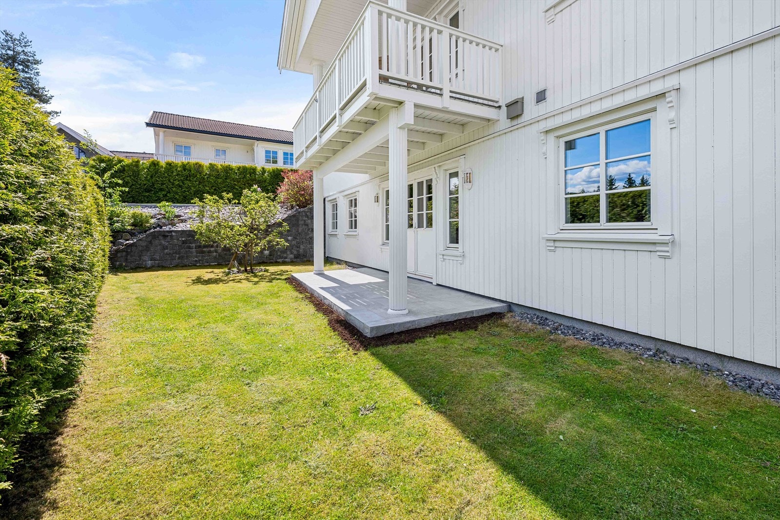 Hage som er pent opparbeidet med plen og diverse beplantning. Galleribilde