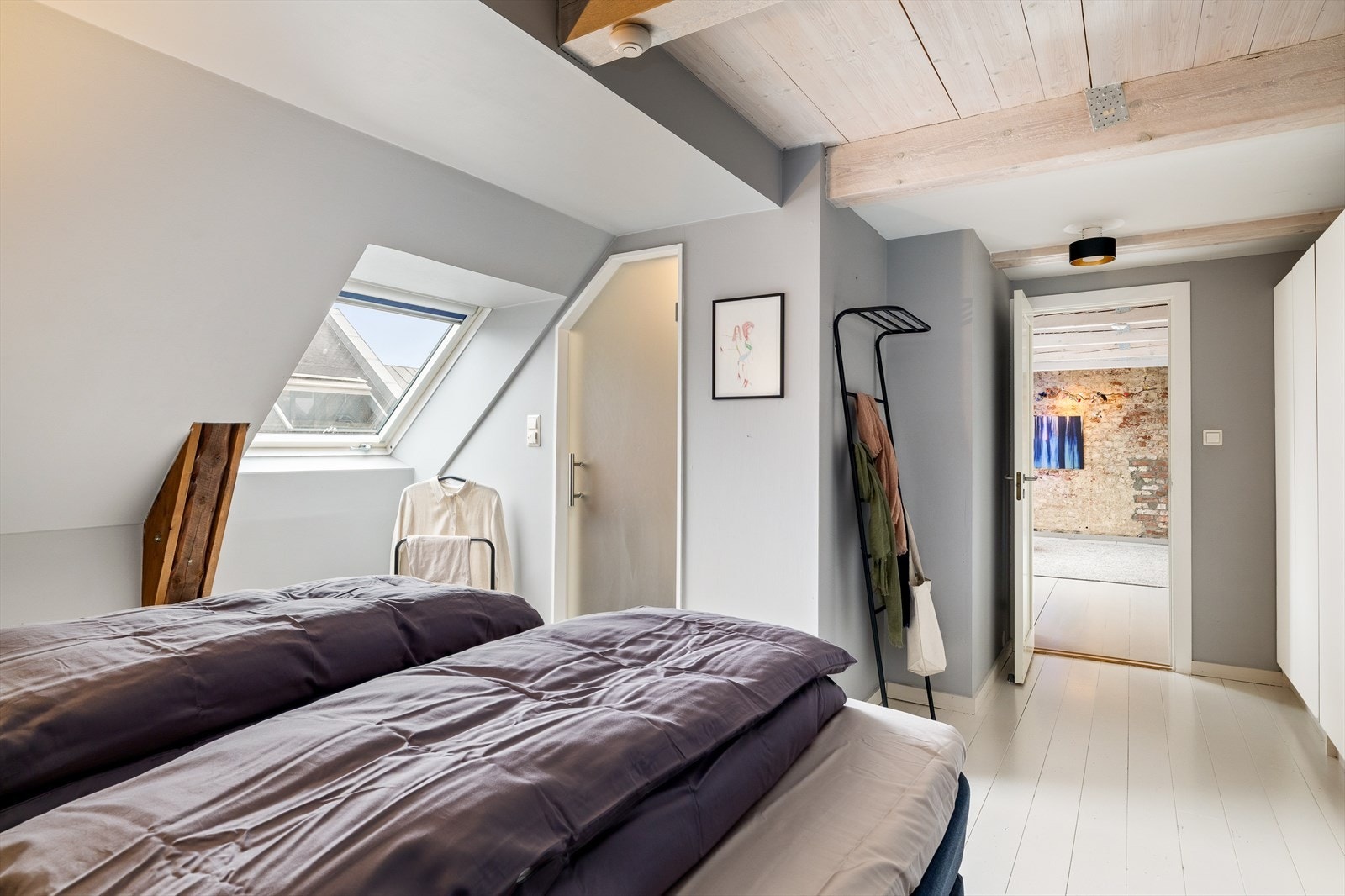 Lyst og romslig soverom med god plass til både seng og oppbevaring - et innbydende rom som gir en behagelig og avslappende atmosfære. Galleribilde