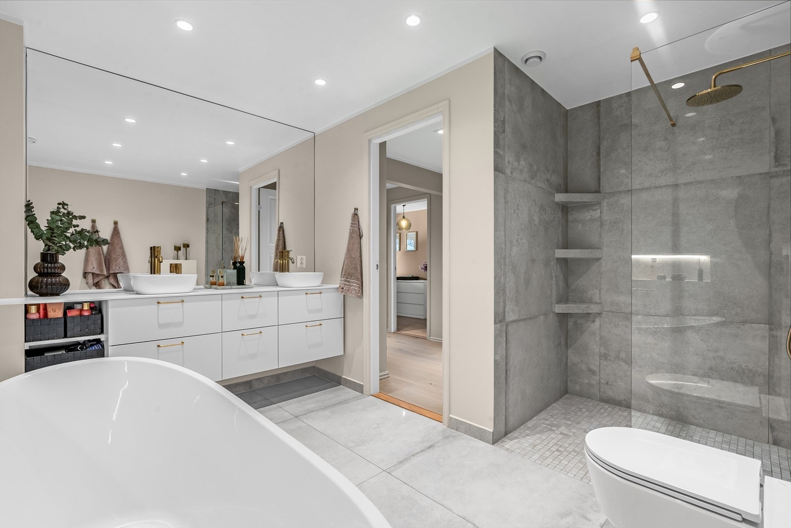 Badet har flere lekre løsninger som stort speil over servantene, plassbygde hyller i dusjsone og hylle over badekar. Galleribilde