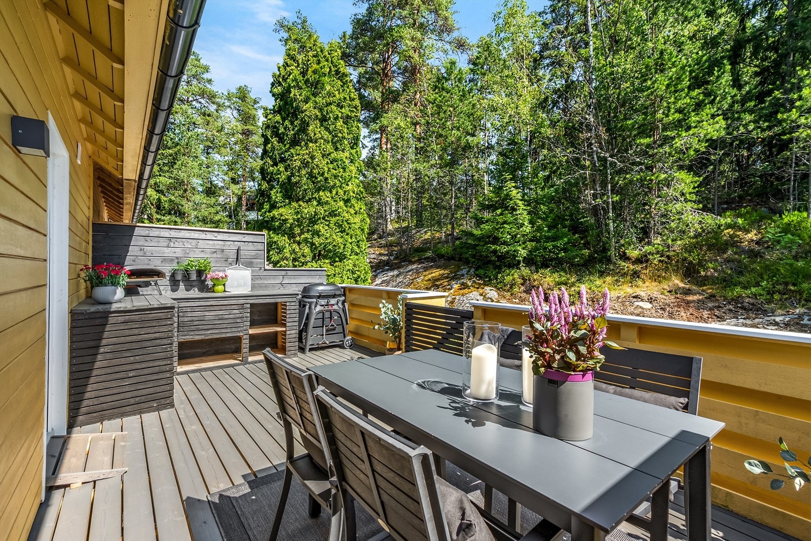 Fra kjøkkenet har du utgang til en solrik og flott terrasse med god plass til spisebord og utekjøkken. Den ene kassen er vanntett og kan brukes som putekasse. Boligen ligger fint til mot skogen. Galleribilde