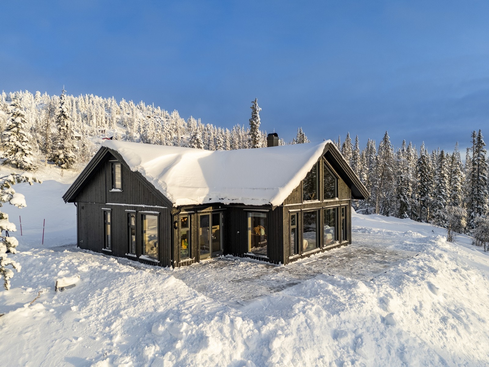 Det er store terrassearealer rundt øst, syd og vest siden av hytta Galleribilde
