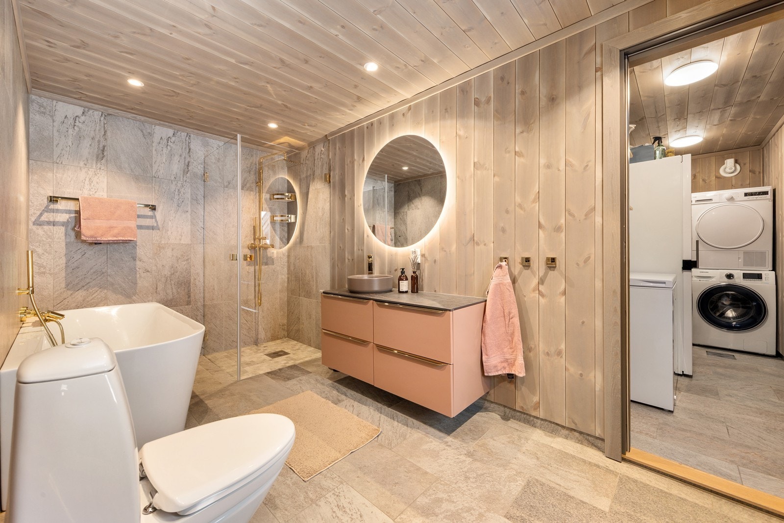 Hovedbad har flislagte gulv med varmekabler, dusjhjørne, badekar, wc og moderne servant innredning. Fra hovedbadet kommer man direkte til vaskerommet som også har egen utgang direkte ut Galleribilde