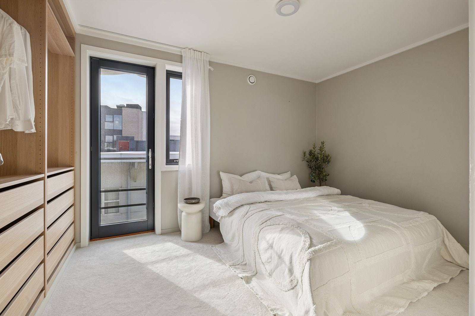 Fra entréen er det adgang til ett av leilighetens to soverom - et lyst og innbydende rom som egner seg godt som hovedsoverom. Det har fransk balkong som gir ekstra luft og lys, og store vindusflater som slipper inn rikelig med dagslys gjennom dagen. Galleribilde