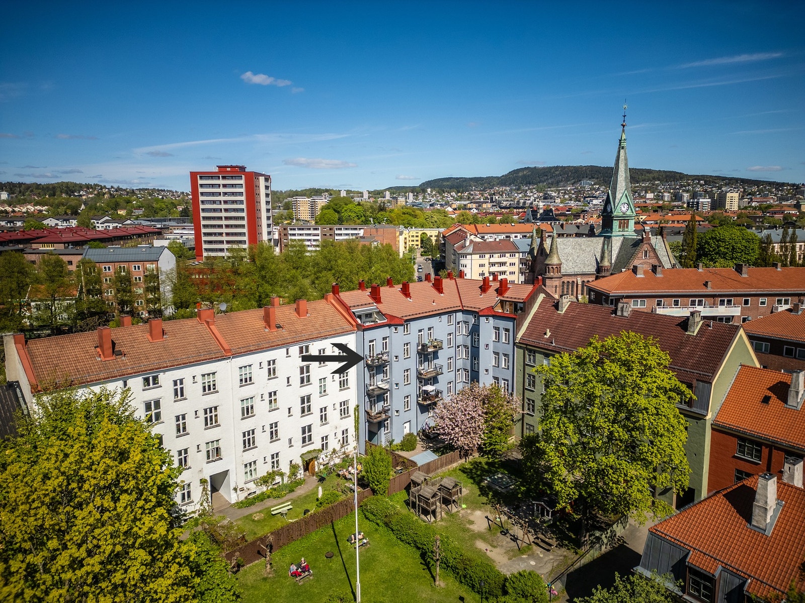 Denne balkongen vender mot en skjermet, rolig og tilbaketrukket bakgård - omringet av flotte grøntområder. Leiligheten ligger i det blå bygget og har øverste balkong til venstre i 4. etasje (se svart pil). Galleribilde