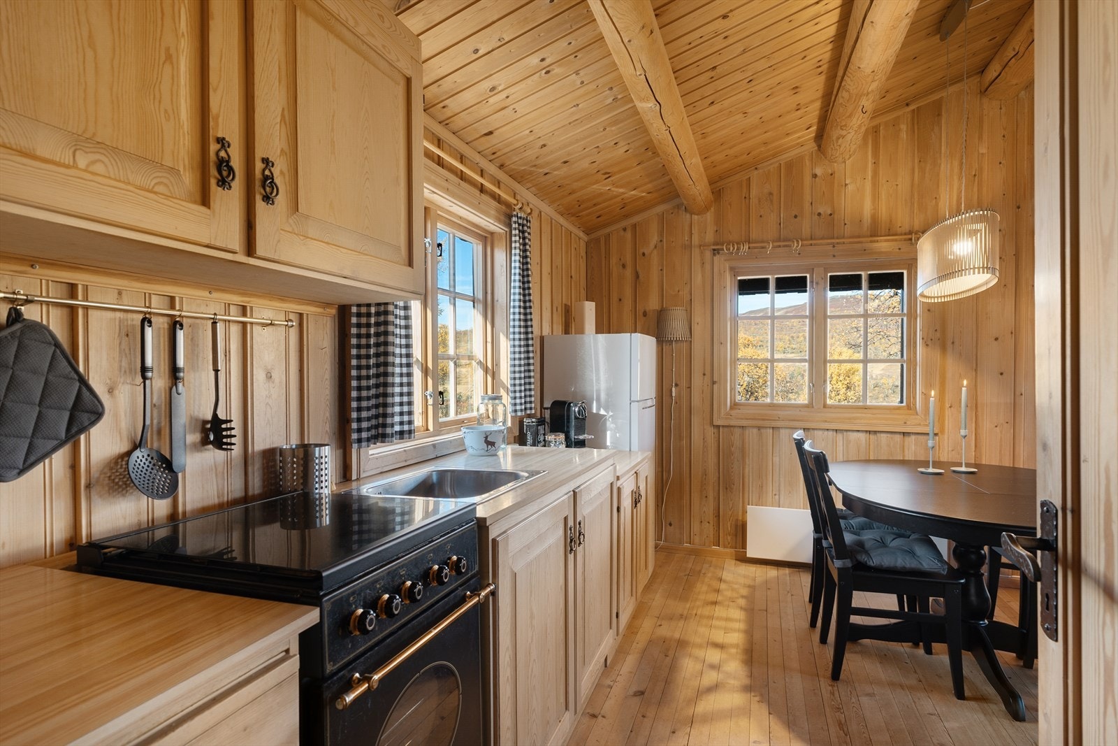 Pent kjøkken i heltre med mye skap- og benkeplass. Gassdrevet komfyr på kjøkken. Galleribilde