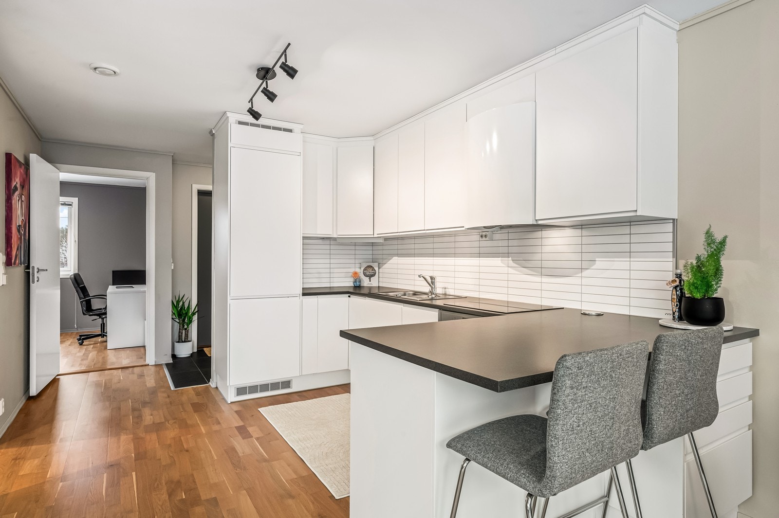 Moderne kjøkkeninnredning med slette fronter og rikelig med skap- og benkeplass. Galleribilde