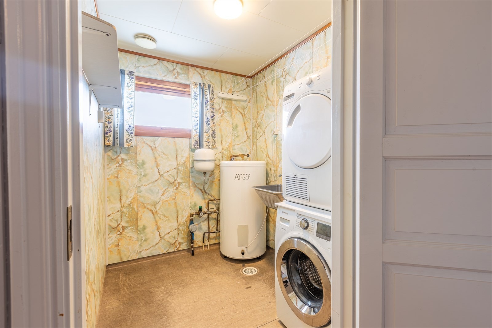 Vaskerommet er utstyrt med skyllekar og opplegg for vaskemaskin, samt en stråleovn som varmekilde. Galleribilde