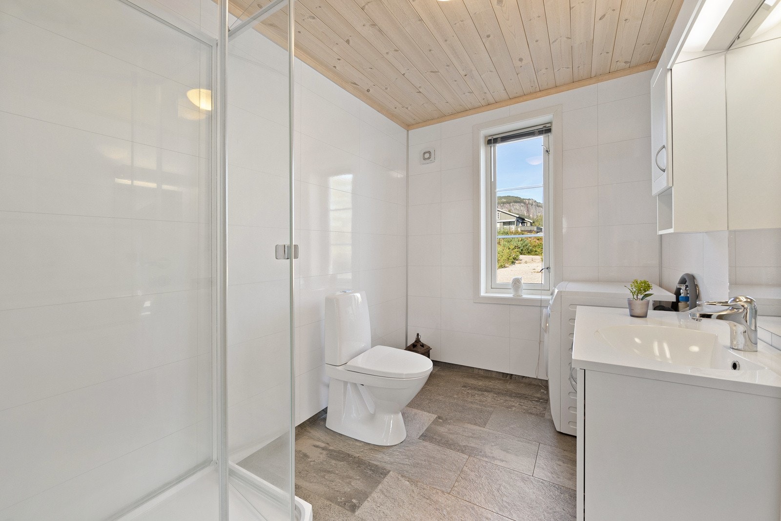 Badet er utstyrt med flislagt gulv og elektriske varmekabler, noe som bidrar til en behagelig opplevelse. Galleribilde