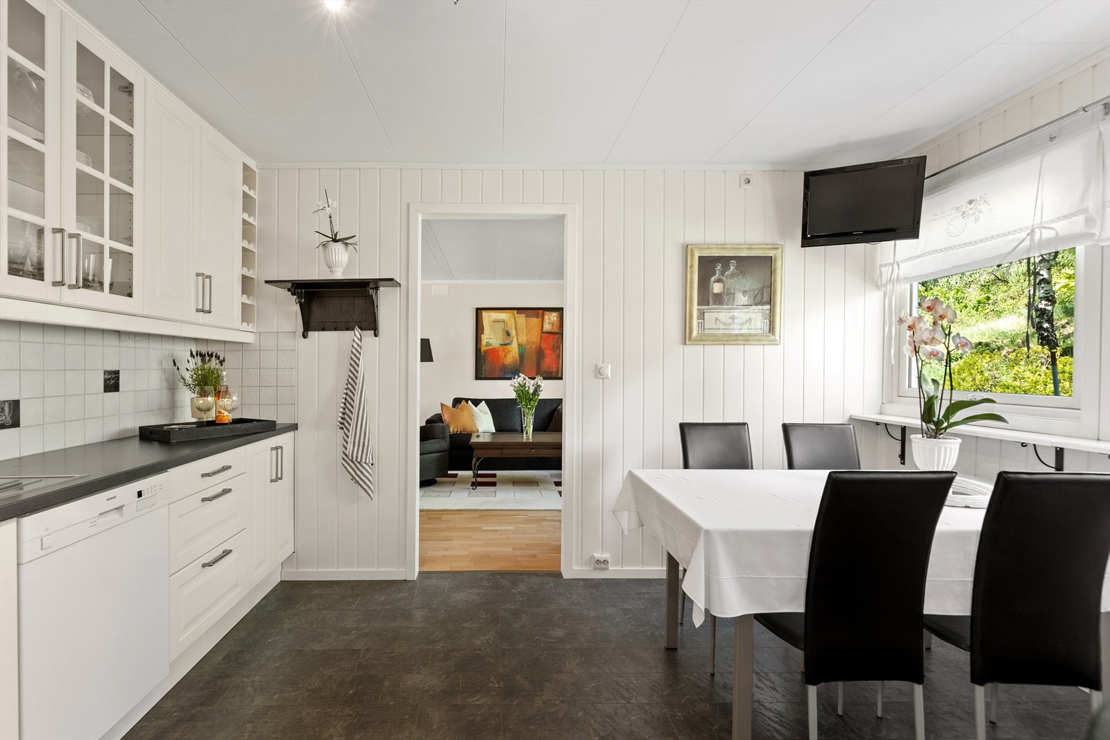 Innredningen består av hvite, profilerte fronter, laminat benkeplate og flislagt sprutsone. Galleribilde