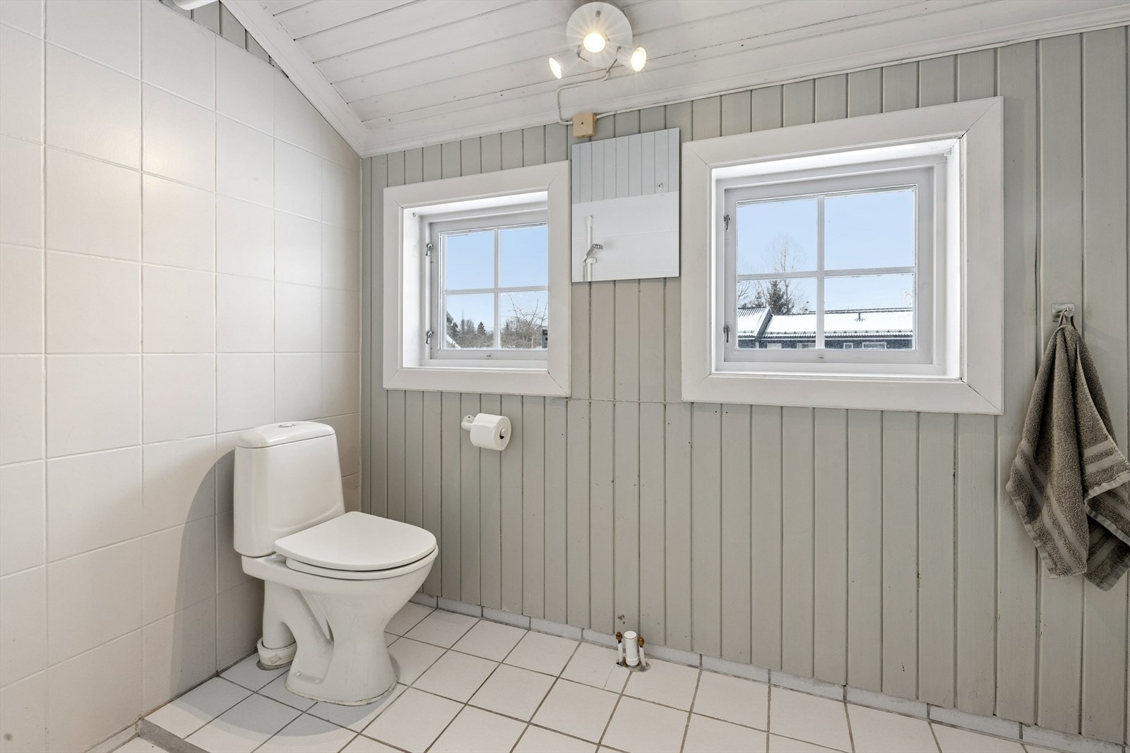 I første etasje finner du et kombinert vaskerom/toalettrom fra 1990, med fliser på gulv med varmekabler, og malte panelvegger. Galleribilde