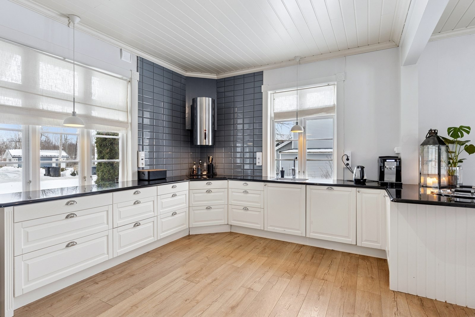 Kjøkkenet har en pen og tidløs innredning fra 2018 med hvite, profilerte fronter og en benkeplate i sort stein. Galleribilde