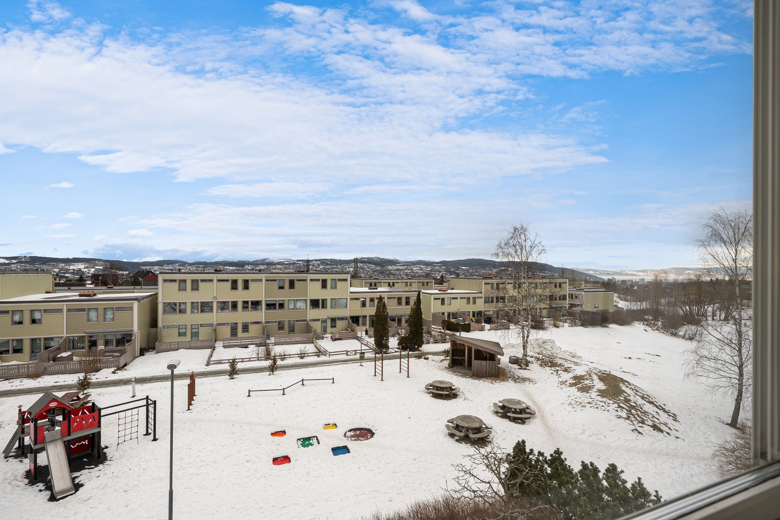 Denne siden av boligen vender ut mot stort friareal med lekeplass, slik kan du holde et øye med barna når de leker ute. Galleribilde