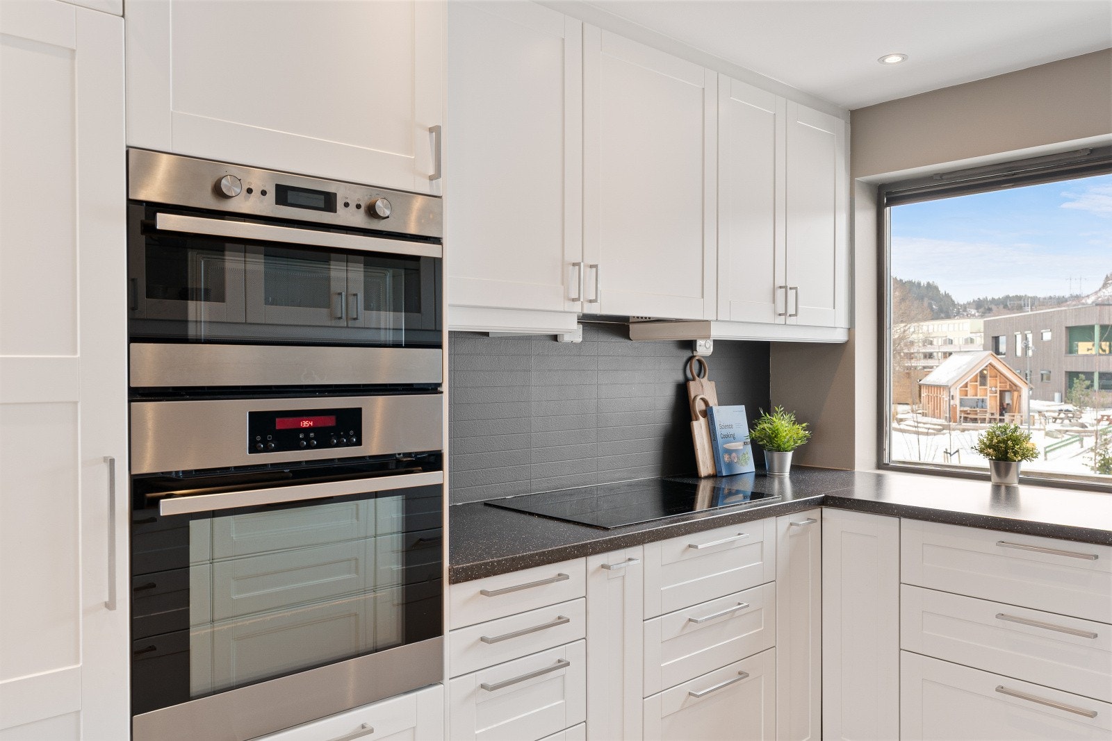 Integrerte hvitevarer med helt kjøleskap, helt fryseskap, stekeovn, mikrobølgeovn, 70 cm induksjonstopp, innebygd ventilator og oppvaskmaskin. Galleribilde