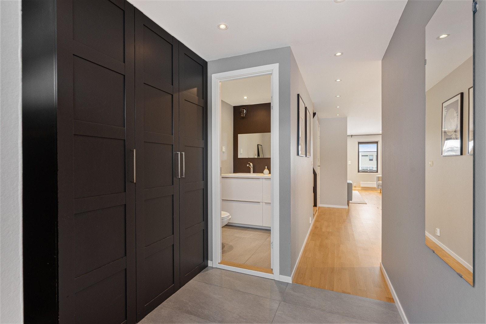 En innbydende entre med god garderobeplass for klær og sko. Gulvet har varmekabler og delikate fliser som gir et eksklusivt førsteinntrykk. Led downlights i himling. Galleribilde