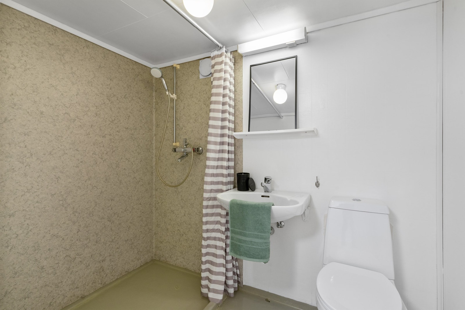 Bad i kjeller er av enkel standard. Dusjnisje, toalett, enkel servant, belegg på gulv og i dusjsone. Galleribilde