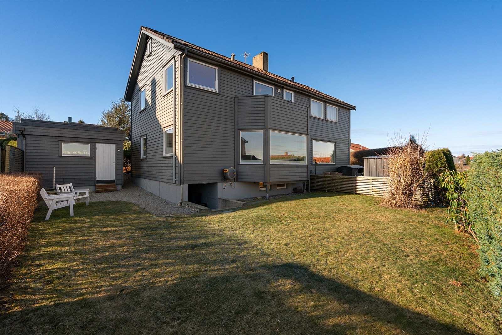 Hage med plass til hagemøbler og trampoline. Nedgang til kjeller også fra hage. Galleribilde