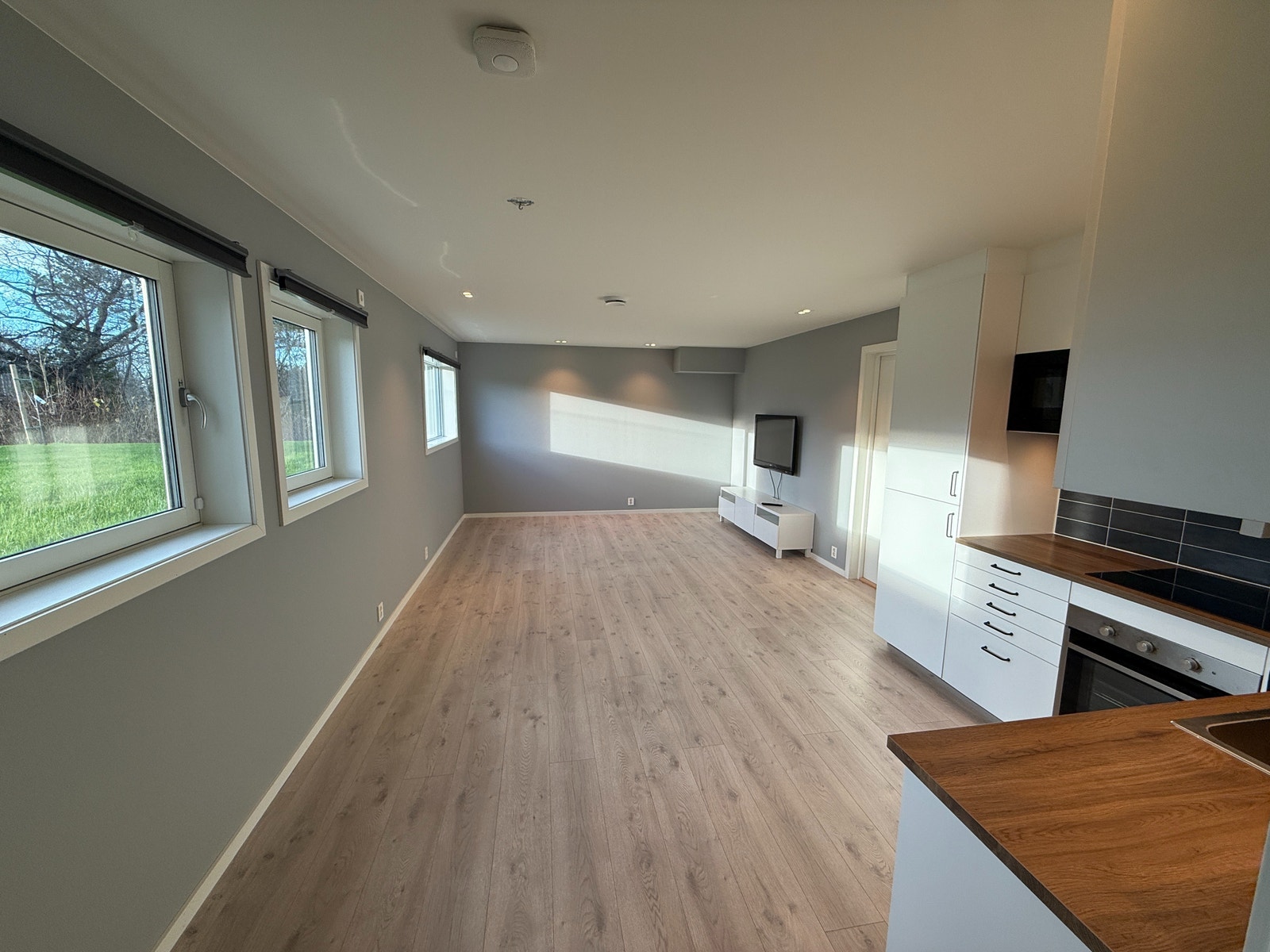 Lyst og åpent oppholdsrom med store vindusflater som gir rikelig med dagslys. God plass til sofagruppe og spiseplass. Galleribilde