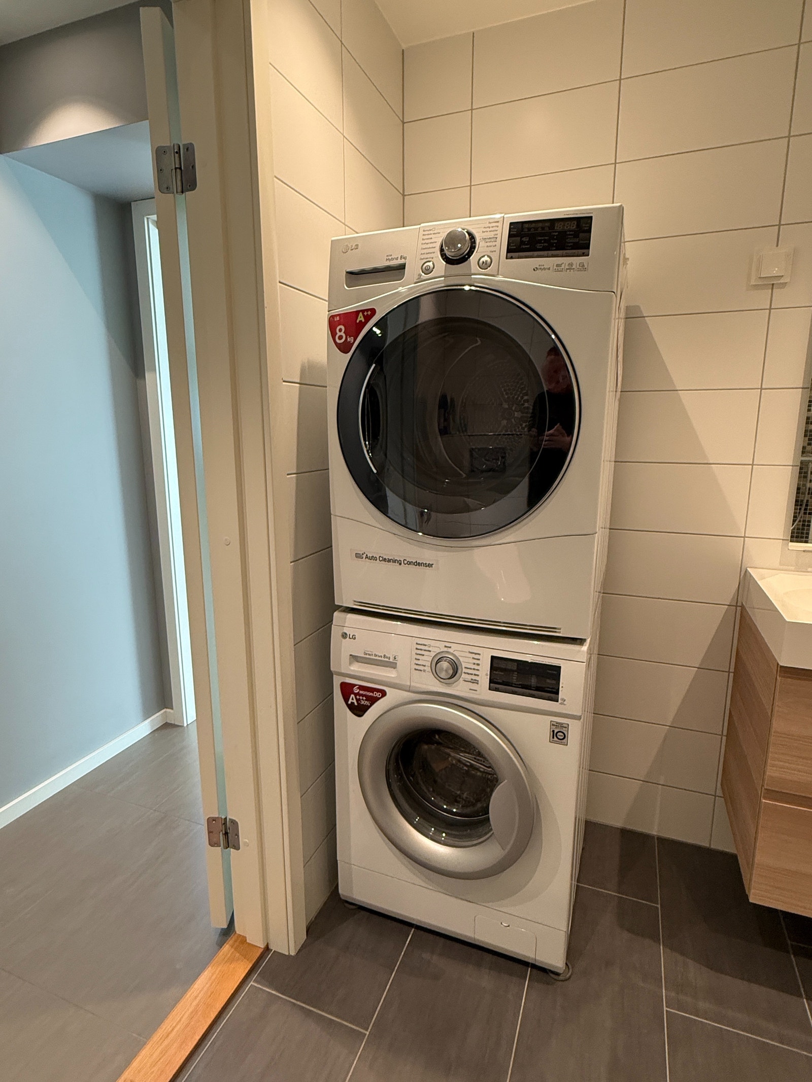 Bad med egen vaskemaskin og tørketrommel stablet i søyle. Galleribilde