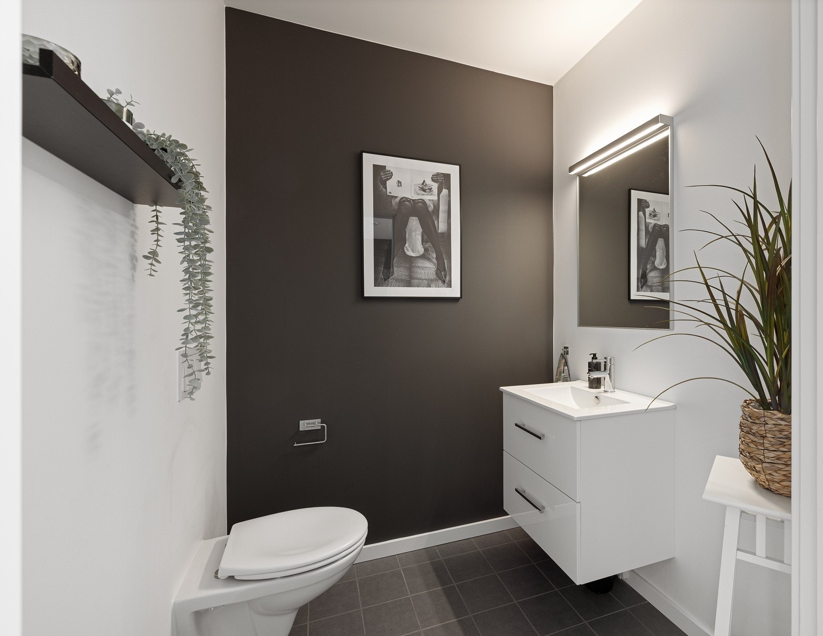 Fra stuen er det inngang til et praktisk toalettrom. Rommet er utstyrt med toalett, servant med underskuffer og speil. Galleribilde