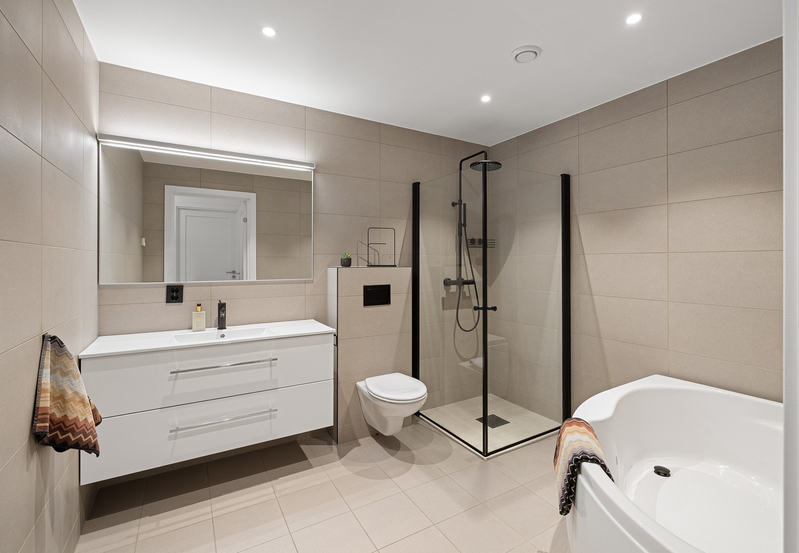 Etasjen har et pent flislagt baderom med vannbåren gulvvarme. Innredning i rommet består av servantskap med nedfelt servant, underskuffer og 1-greps blandebatteri. Galleribilde