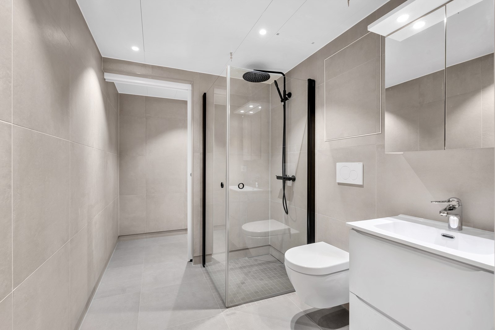 Lekkert, komplett flislagt bad med storformatfliser i behagelige farger. Grå gulvfliser som tilvalg, og beige på vegger. Galleribilde