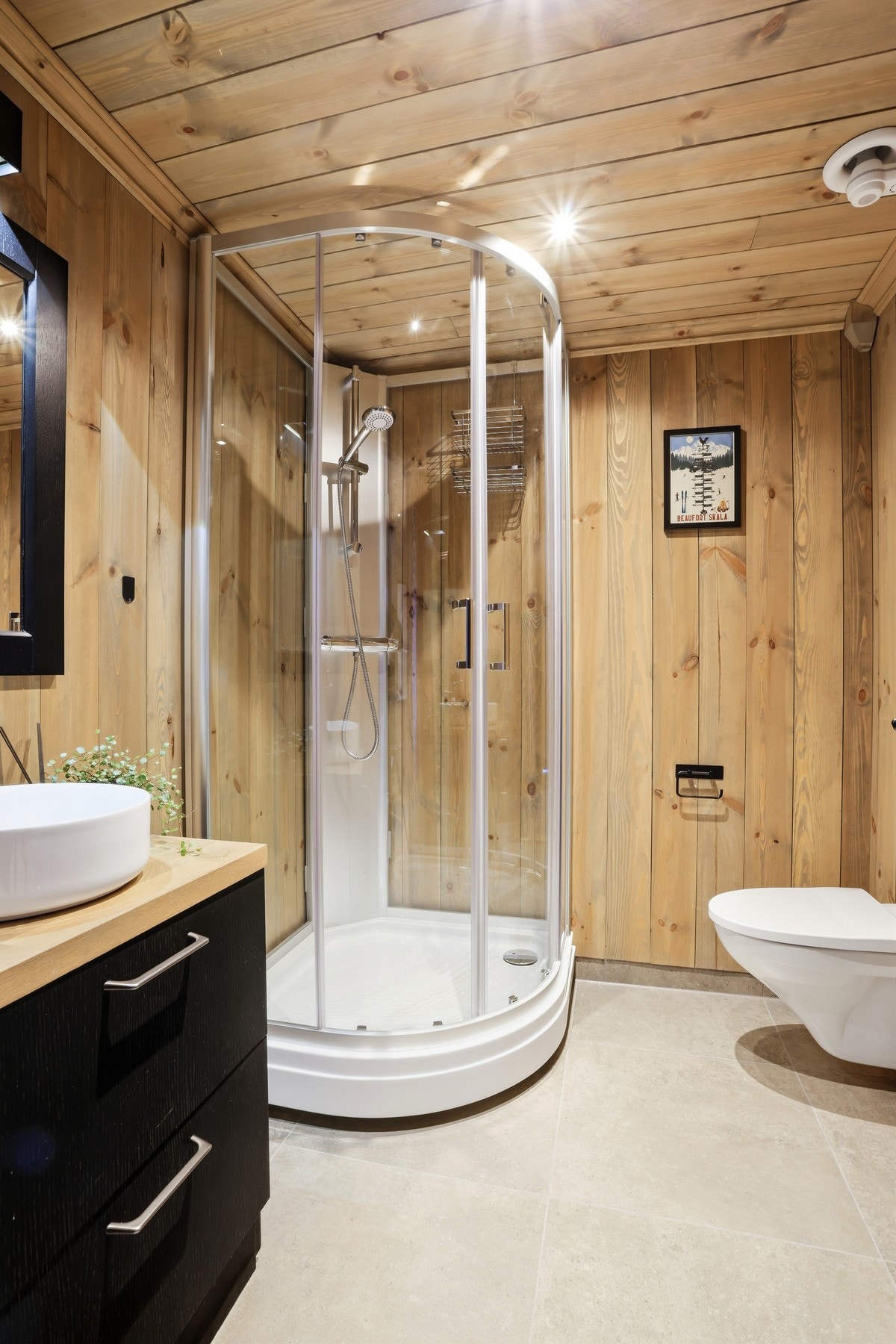 Baderom i 2.etasje har flislagt gulv og inneholder dusjkabinett, innredning med servant og veggmontert toalett Galleribilde