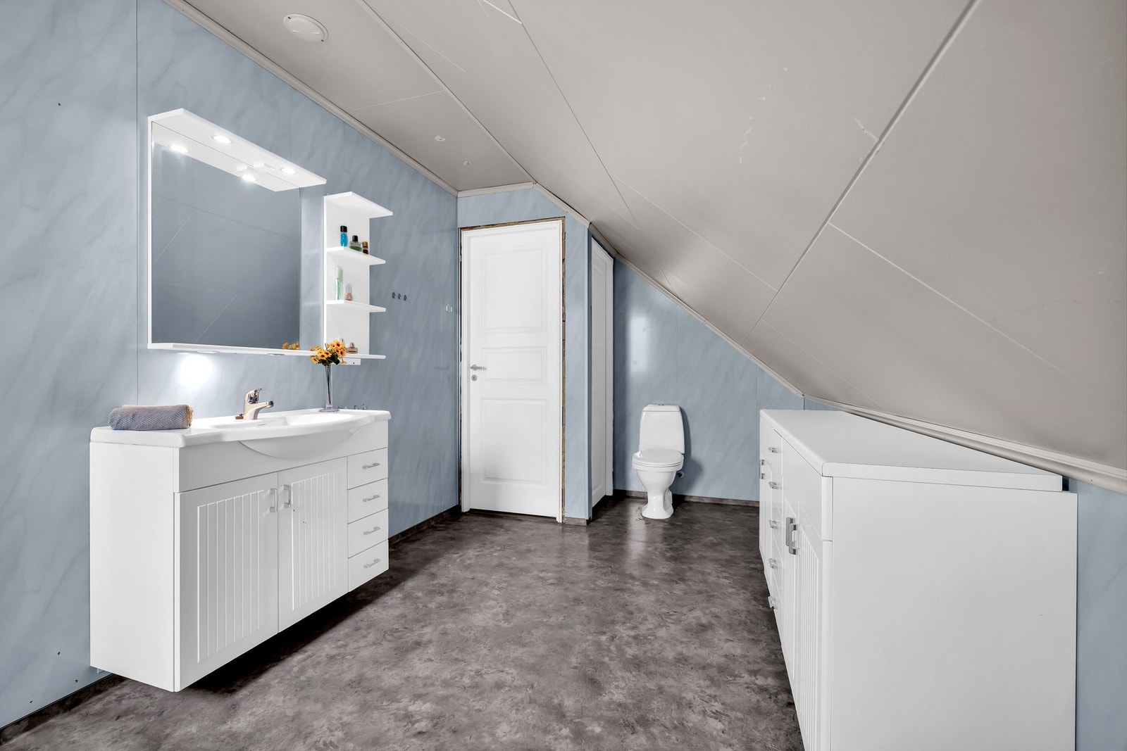 Her finner du et vegghengt servantskap, gulvstående toalett og et romslig badekar med dusjarmatur. Galleribilde