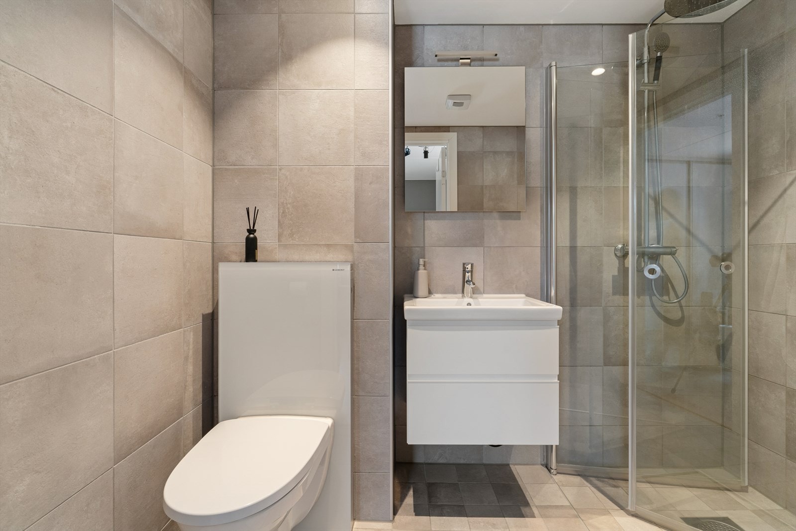 Baderommet består av toalett, servant og dusjhjørne med glassvegger. Galleribilde