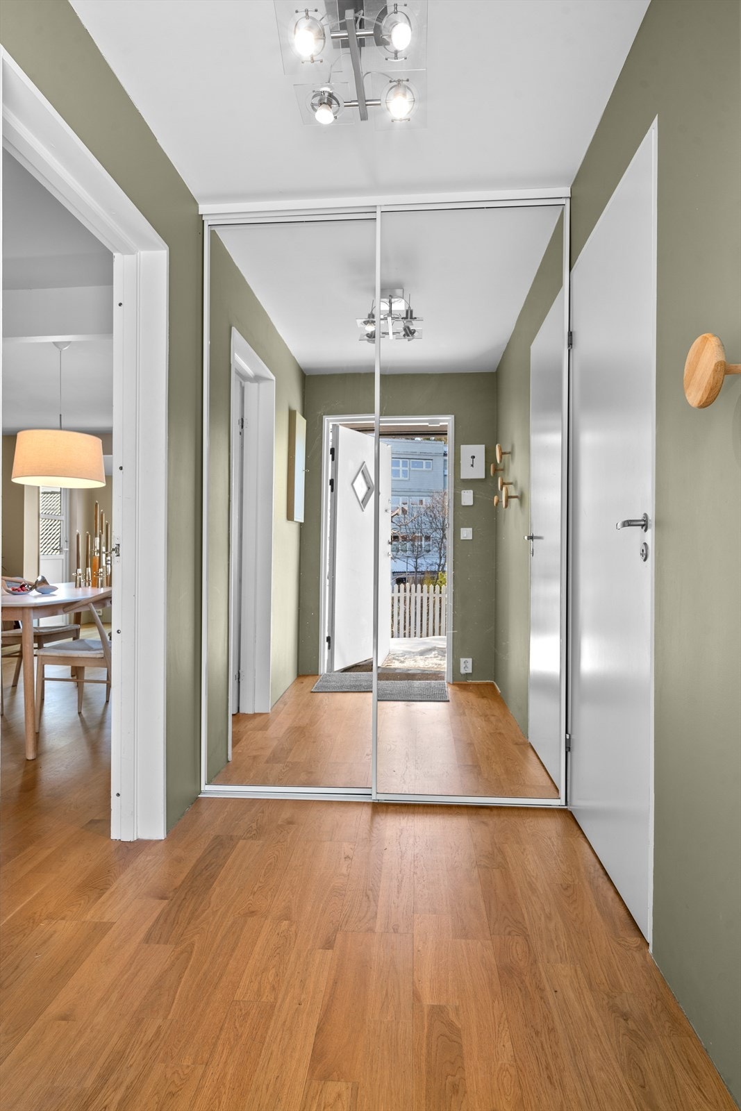 Innbydende entré med plass til å henge fra seg yttertøy og sko i skyvedørsgarderobe med speilfronter. Galleribilde