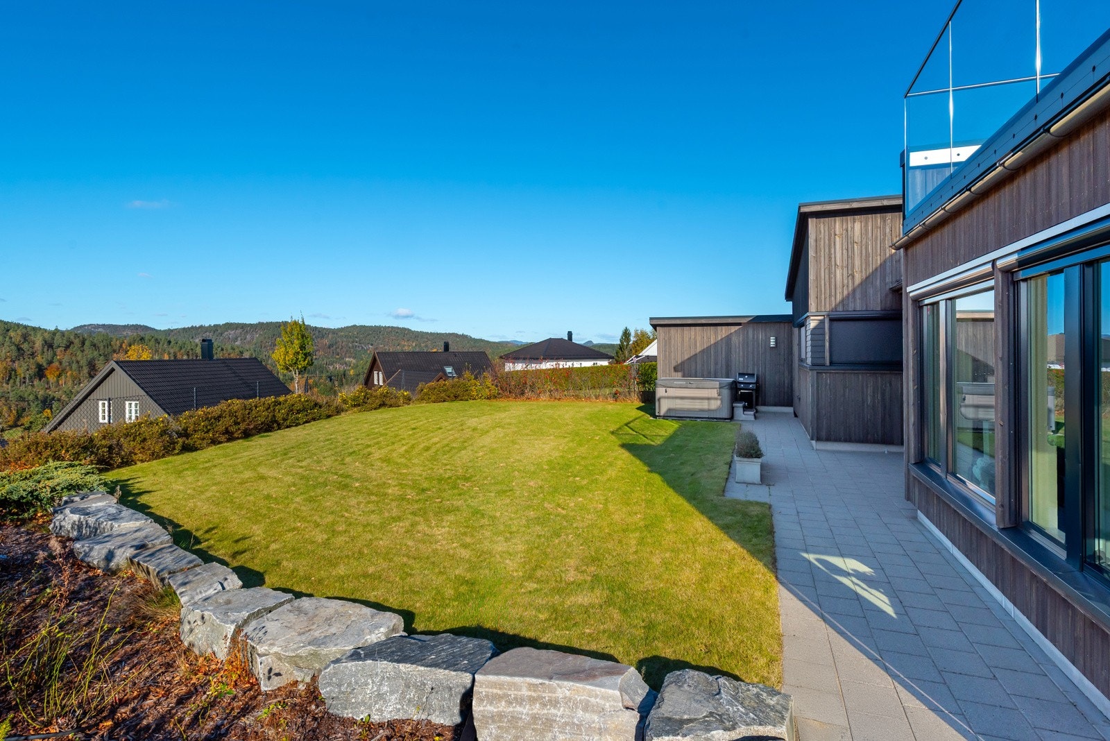 Her er det mer en nok boltreplass for liten og stor - pent opparbeidet med plen og beleggningstein mot gjerde og hekk. Usjenert og solrikt! Galleribilde