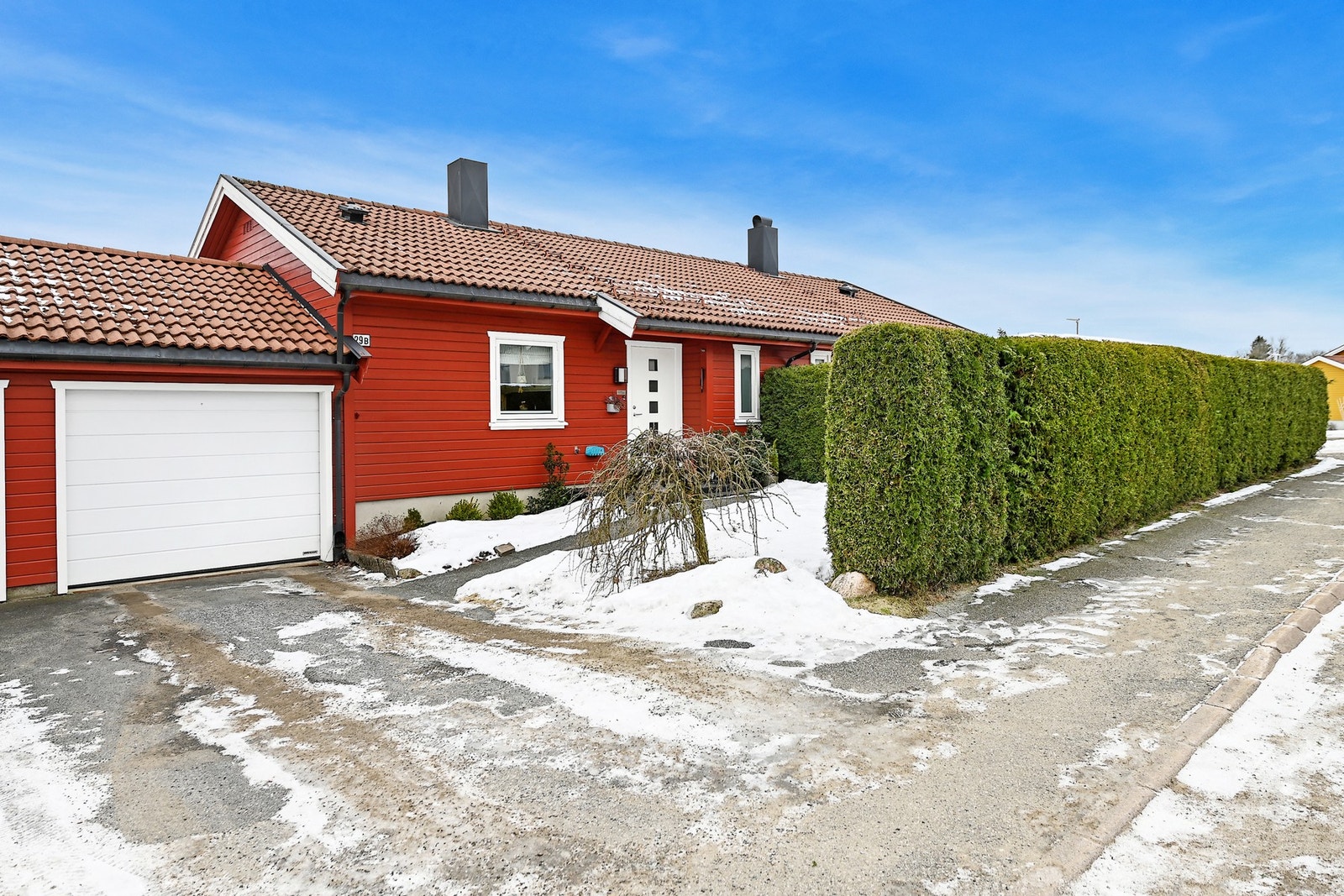 Boligen er med garasje, skjermet uteområde og velstelt hekk. Galleribilde