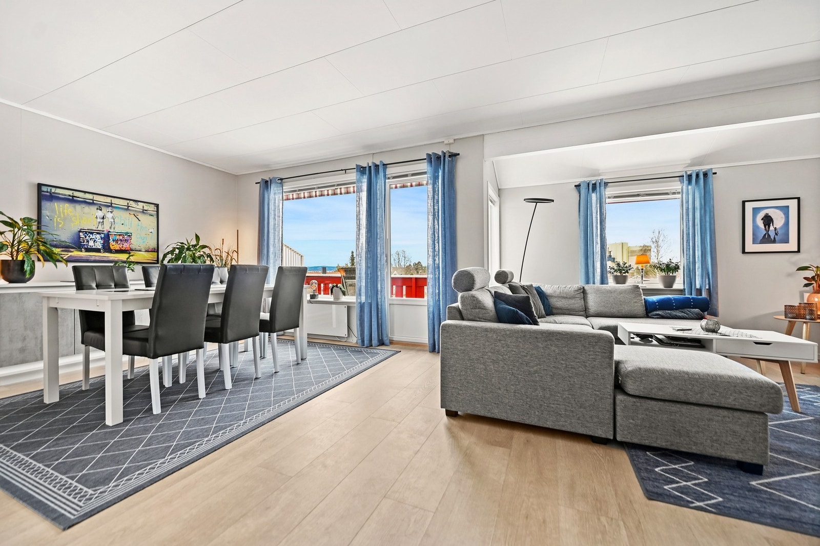 Rommet har store vinduer som gir godt med naturlig lys og utsikt mot en terrasse. Galleribilde