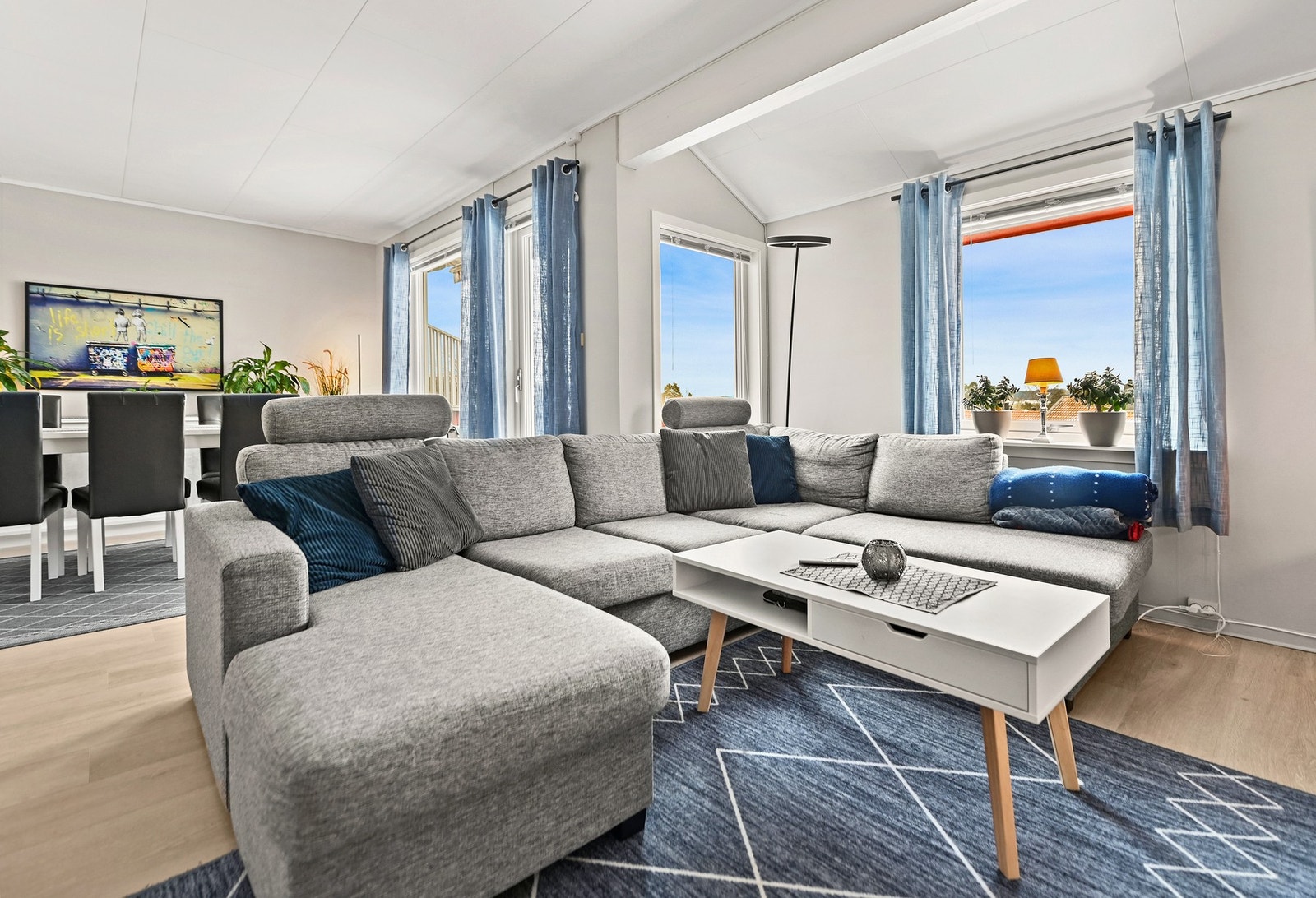 Lyst og romslig stue med store vinduer som gir mye naturlig lysinnslipp. Galleribilde