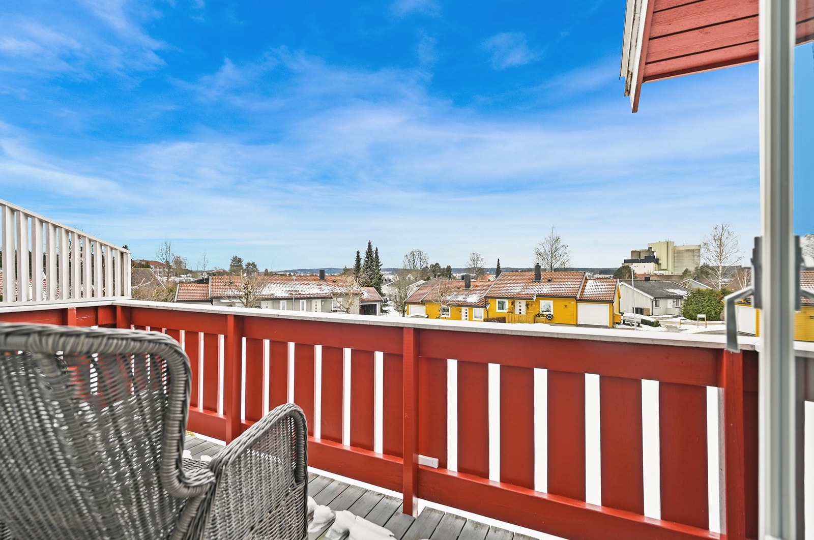 Balkongen har utsikt over nærområdet med hus og vegetasjon, og gir en luftig følelse. Galleribilde