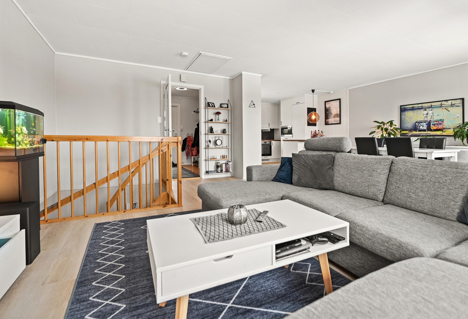 Lyst og romslig oppholdsrom med åpen kjøkkenløsning og praktisk trappeadkomst. Galleribilde