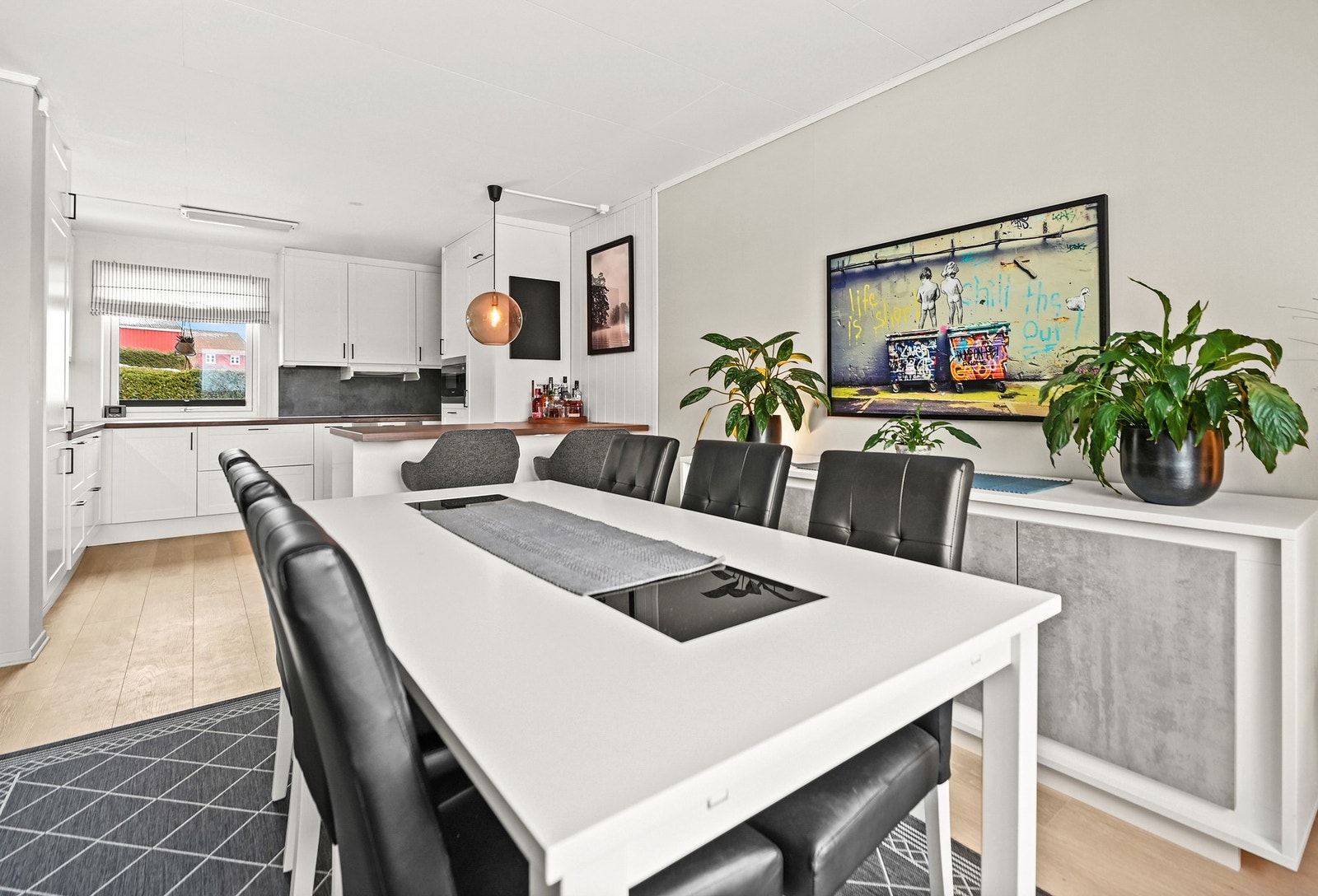 Lyst kjøkken med spiseplass og moderne innredning. Store vinduer gir godt med naturlig lys. Galleribilde