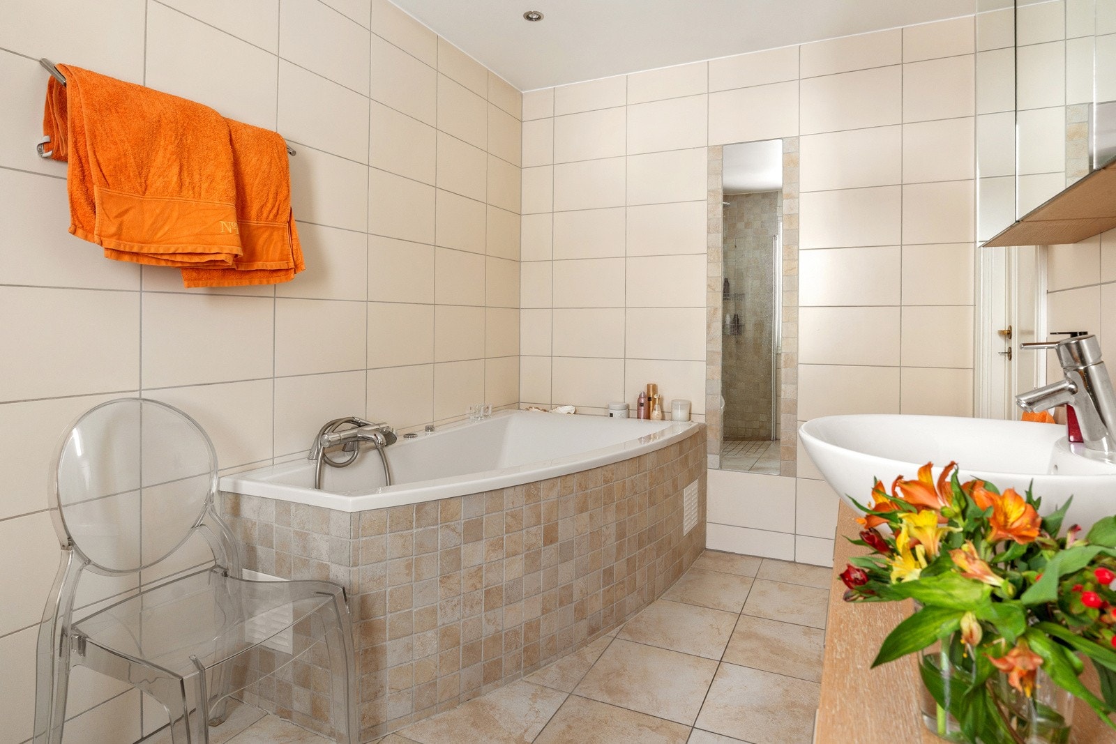 Dusjhjørne med buede svingdører, sluk i sone, regnsfalldusj, termostatstyrt blandebatteri og veggmontert toalett. Galleribilde