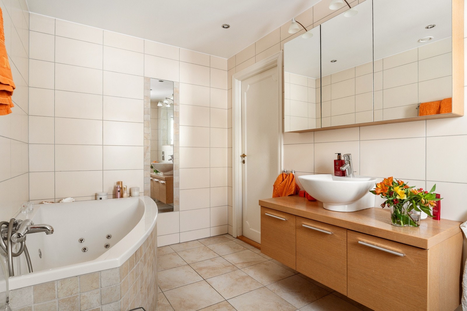 Speilskap med lysarmatur på vegg over servant. Videre er det innfliset badekar med ventilasjonsluker, samt innmurt høyspeil i vegg ved badekar. Galleribilde