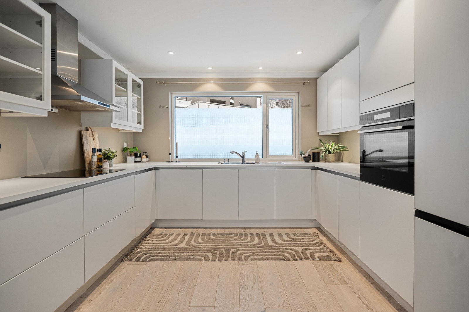 Stilrent kjøkken med rikelig benkeplass og gode oppbevaringsløsninger Galleribilde