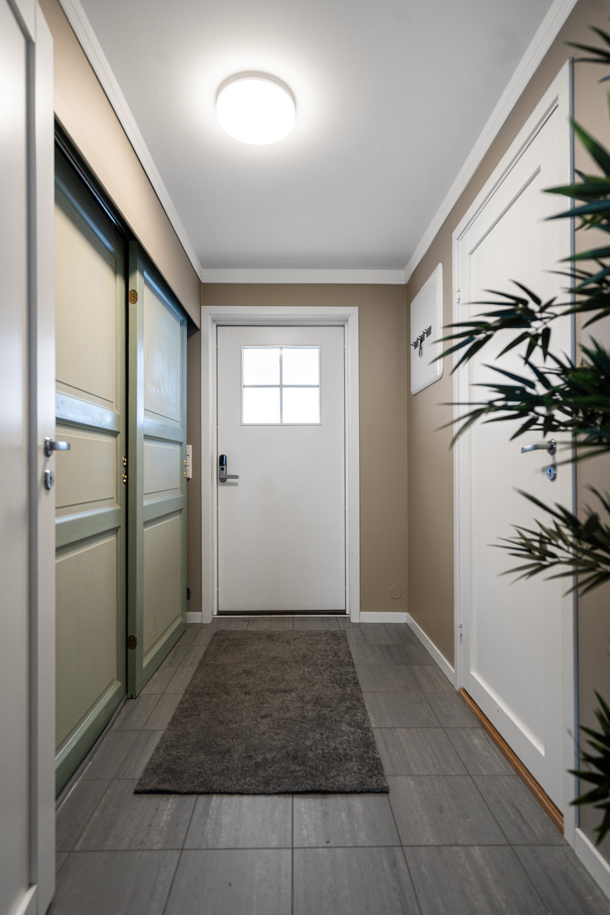 Romslig og praktisk gang med skyvedørsgarderobe, flislagt gulv og gulvvarme Galleribilde