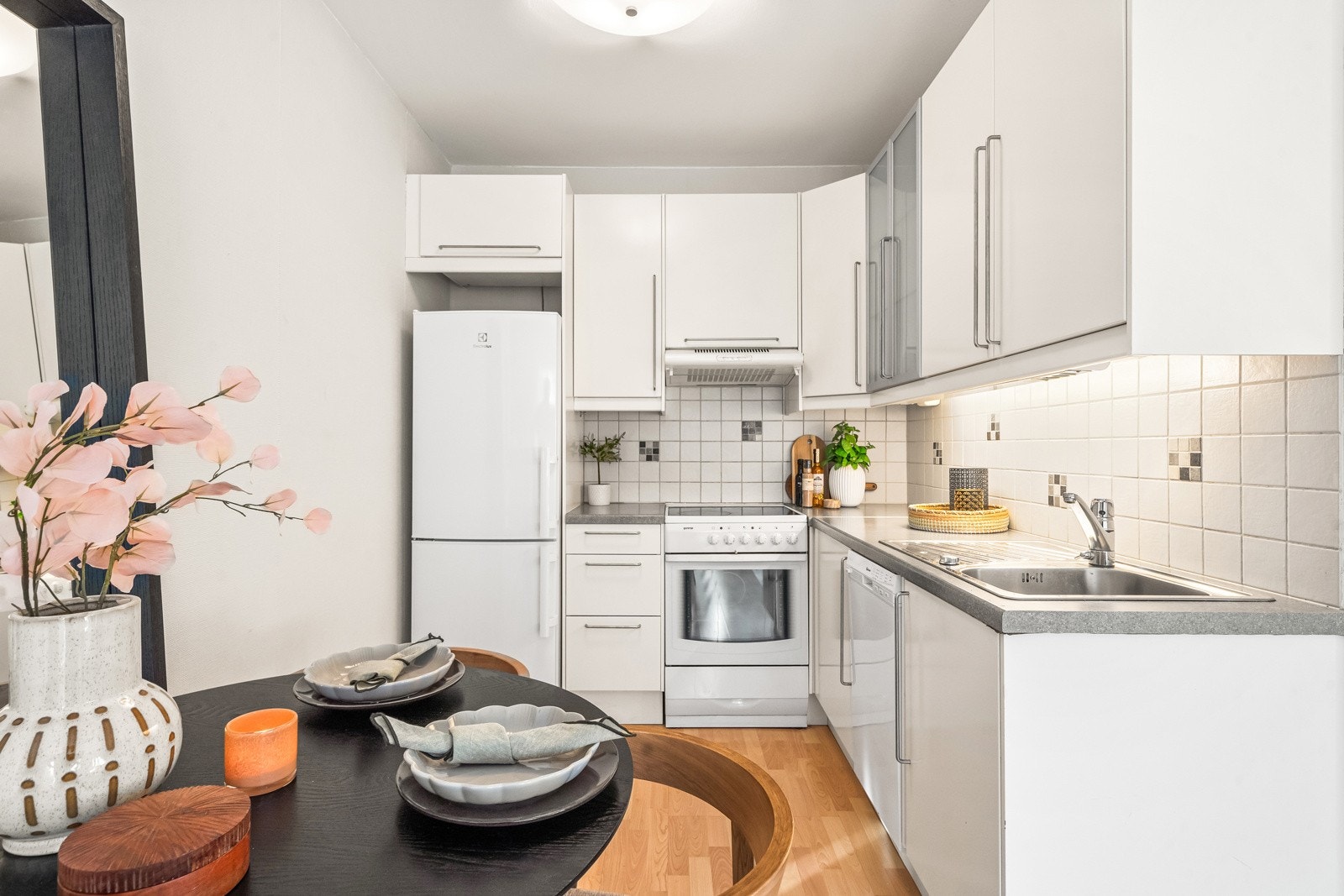 Tidløst kjøkken fra 2002 med åpen løsning mot stuen. Kjøkkeninnredning besteåened av glatte fronter og benkeplate av laminat. Galleribilde